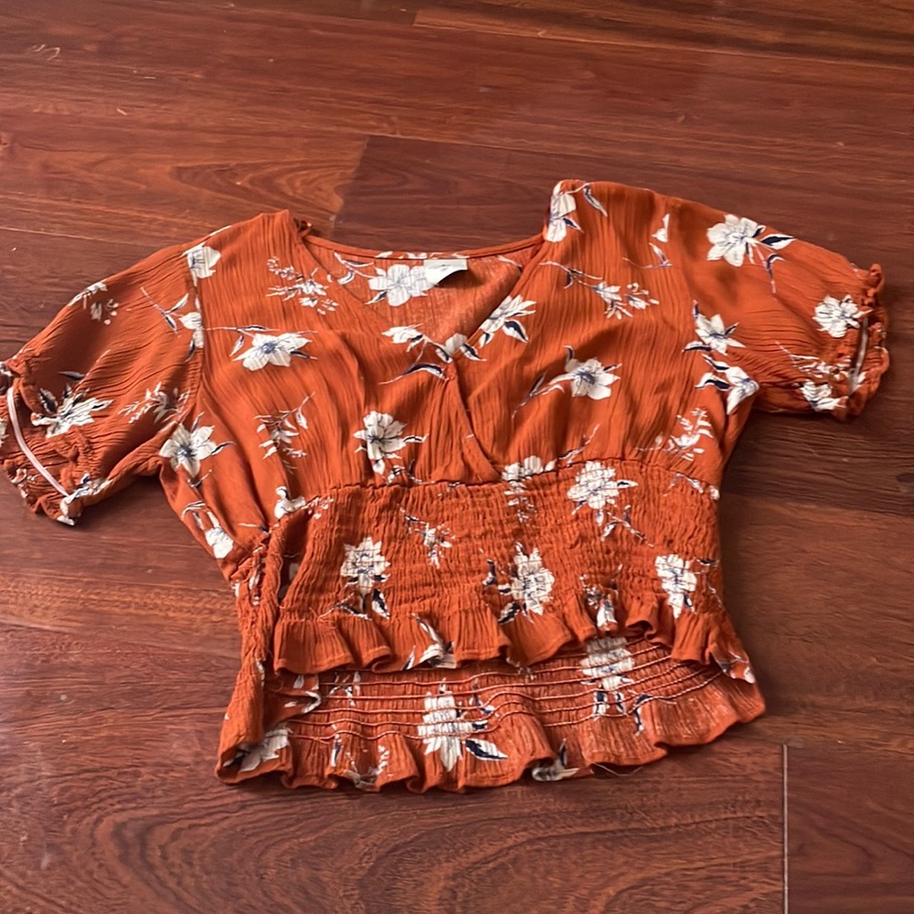 This is a size small orange shirt with flowers on it from paper crane.